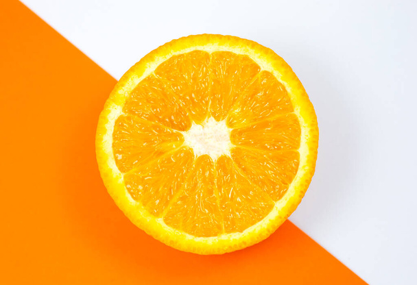 Közelkép Orange Fruit a fehér és a narancs háttér. Citrus félbevágva, belül, makró kilátással. Minimalizmus, eredeti és kreatív kép. Gyönyörű természetes tapéta. - Fotó, kép