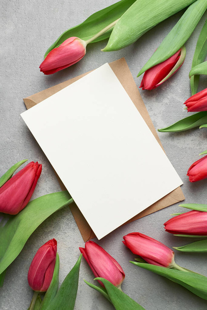 Greeting card with fresh red tulip flowers on grey concrete background, card mockup with copy space - Fotografie, Obrázek