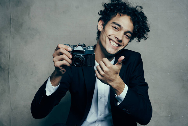 χαριτωμένος τύπος κρατώντας κάμερα κλασικό κοστούμι gesturing με τα χέρια χαμόγελο μοντέλο χαρά - Φωτογραφία, εικόνα