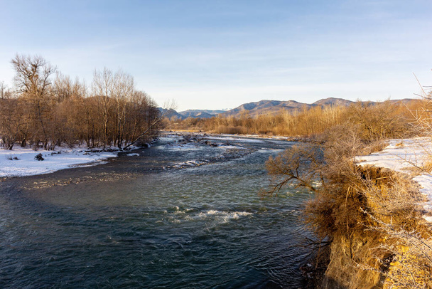 Winter in the foothills, an ice-free river on a frosty morning in the rays of the rising sun. - Foto, Bild
