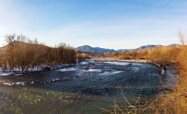 Winter in the foothills, an ice-free river on a frosty morning in the rays of the rising sun. - Foto, Bild