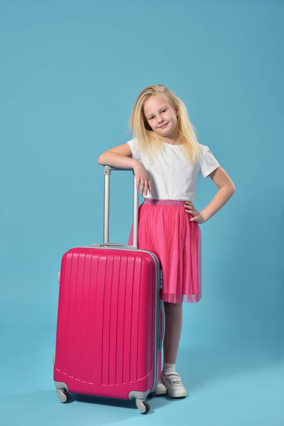 Smiling girl child stands with her pink suitcase - Foto, immagini