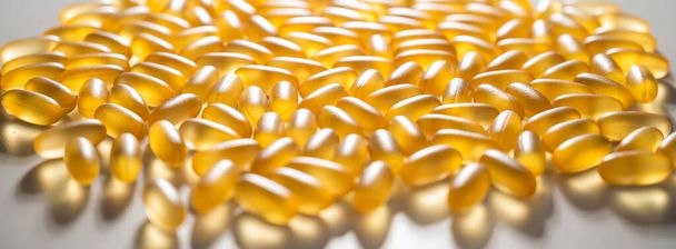 Close-up of golden omega three capsules. Dietary supplement fish oil - Фото, зображення