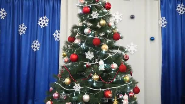 Weihnachtsbaum drinnen mit Girlanden geschmückt - Filmmaterial, Video