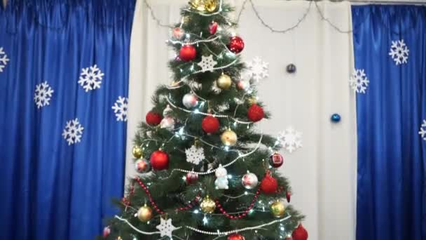 Weihnachtsbaum drinnen mit Girlanden geschmückt - Filmmaterial, Video