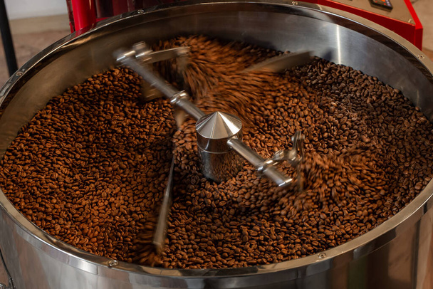 Kávét sütök. Kávébab egy pörkölőgépben. Vágott felvétel, közelkép, vízszintes, háttér. A termelés és az ipar fogalma - Fotó, kép