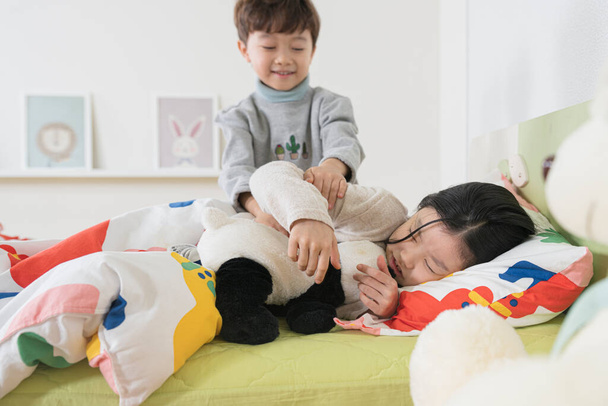 Asian young brother and sister children sleeping in bed - Foto, afbeelding