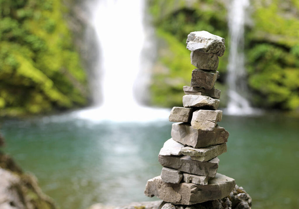купа каменів під назвою Орієнтація Людина, щоб вказати правильний напрямок в горах це невеликий ставок з водоспадом на задньому плані
 - Фото, зображення