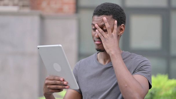 Портрет разочарованного африканского мужского дизайна с потерей на планшете  - Фото, изображение