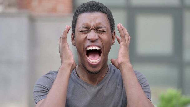 Portret van boze jonge Afrikaanse man schreeuwen, schreeuwen - Foto, afbeelding
