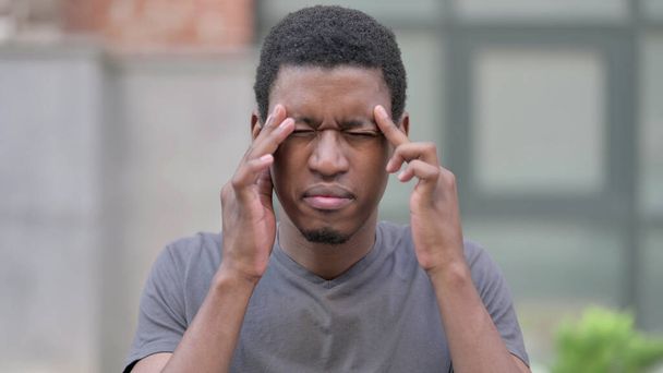Portret zmęczonego młodego Afrykanina z bólem głowy - Zdjęcie, obraz