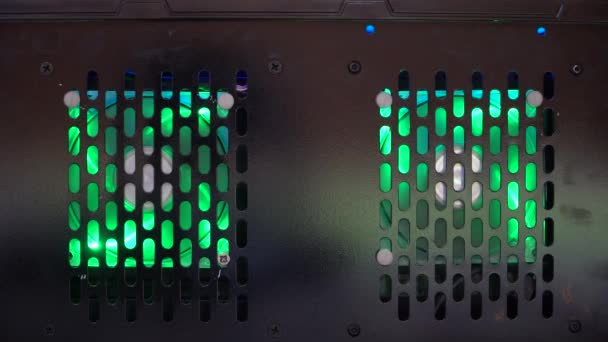 Fundo perfurado de uma caixa de PC com dois ventiladores led verdes de 80mm. Os fãs resfriam o PC com ar, e a energia é fornecida por fios. A luz de fundo torna o computador mais bonito. Vídeo sobre um PC moderno. - Filmagem, Vídeo