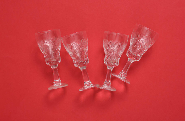 Empty retro wine glasses on red background  - Foto, afbeelding