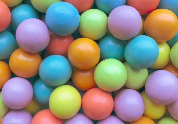 Background from multicolored bright small wooden balls of blue, yellow, red, lilac and green colors. A beautiful summer bright background for your projects. - Photo, Image