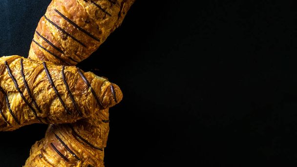 Textura croissant. Desayuno francés cruasanes, pan de repostería fresco con chocolate en panadería sobre fondo de piedra oscura. Panadería productos concepto de cafetería, plano laico - Foto, Imagen