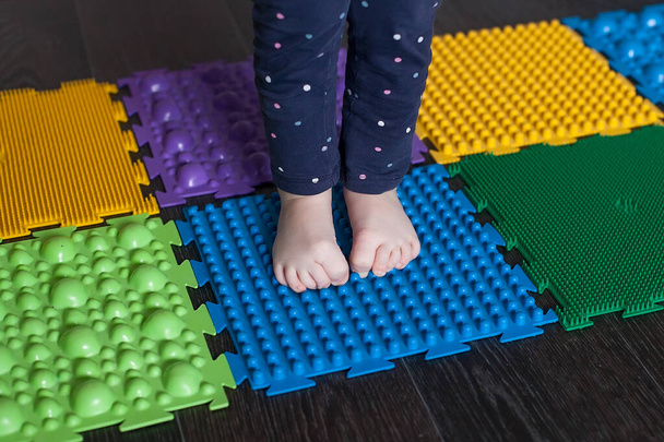 Foot massage mat for babies. Prevention of flat feet and hallux valgus. Orthopedic massage puzzle mats for the development of children. - Photo, Image
