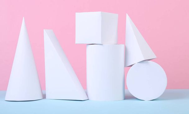 Белые геометрические фигуры на сине-розовом пастельном фоне. Состав различных геометрических объектов. Концептуальное искусство. Абстрактный фон, минимализм - Фото, изображение