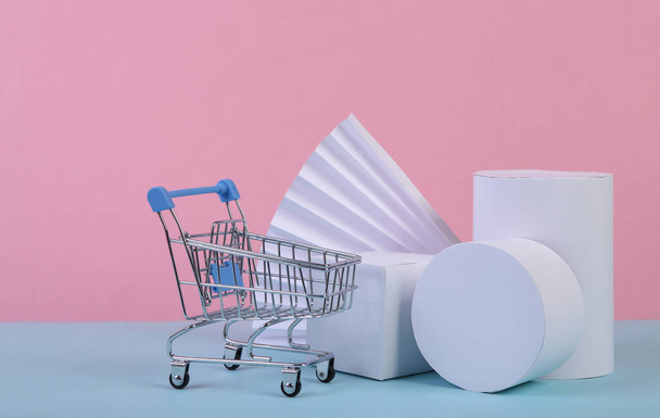 Shopping trolley and geometric shapes on blue pink pastel background. Sale, product presentation. Abstract background, concept art, minimalism. geometric composition - Photo, Image
