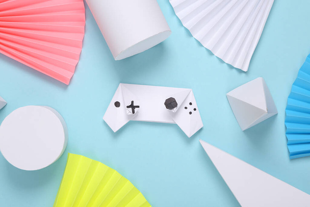 Origami gamepad on abstract background with geometric shapes. Minimalism. Concept art. Creative layout - Foto, afbeelding
