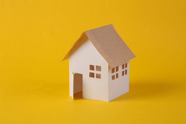 Mini paper house model on yellow background  - Фото, зображення