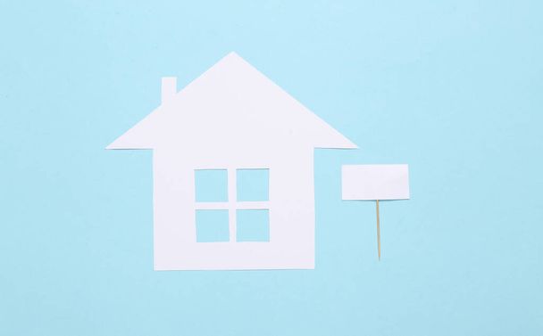 House for sale. Paper house with blank sign on blue background  - Photo, Image