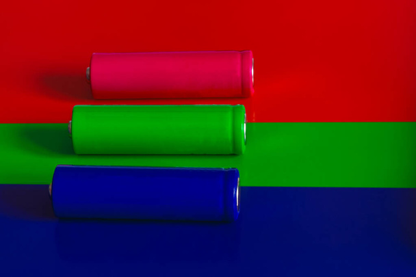 Green, red and blue batteries on the background. Copy space. Elements of a food of type AA. - Fotoğraf, Görsel