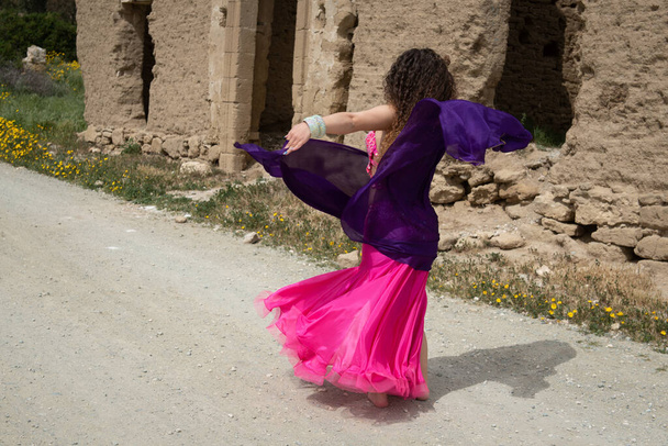Woman dance belly oriental dancing in coloured costume outdoor. Dance in the street - Photo, Image