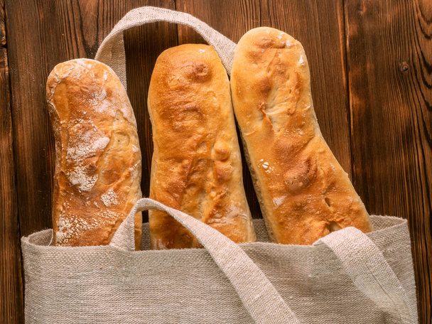 Baguettes In A Bag On Wooden Background - Photo, Image