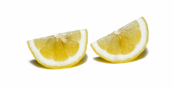 limones cortados en círculos, rebanadas sobre un fondo blanco fotografiado por macrofotografía - Foto, imagen