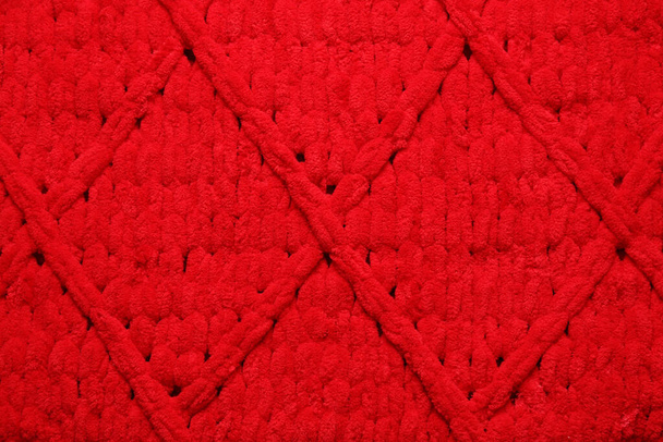 Czerwona wełniana tkanina z geometrycznym wzorem jako tło, widok z góry - Zdjęcie, obraz