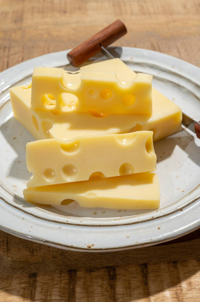 Käse-Sammlung, Blöcke französischen Emmentaler-Käses mit vielen runden Löchern aus Kuhmilch in Großaufnahme - Foto, Bild