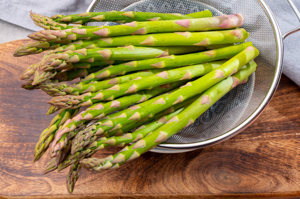 Grappolo di asparagi verdi freschi maturi verdure biologiche pronte da cuocere o grigliare - Foto, immagini