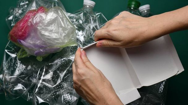 POV rasgón y caja de cartón plegable preparándose para reciclar - Foto, Imagen