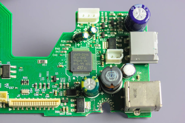Een groene elektronische printplaat plat. Bovenaanzicht van pcb board circuit close-up. Radio amateur ontwerpen voor het elektrisch en mechanisch aansluiten van verschillende elektronische componenten. Technologische achtergrond - Foto, afbeelding