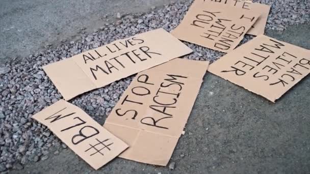Paper banners with inscriptions BLM, ALL LIVESMATTER, STOP RACISM lie on ground - Footage, Video
