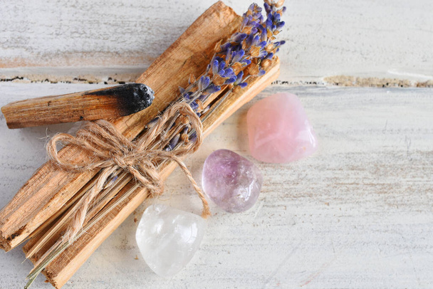 Uma imagem de perto de varas de incenso de madeira sagrada com cura rosa de quartzo e cristais de ametista.  - Foto, Imagem
