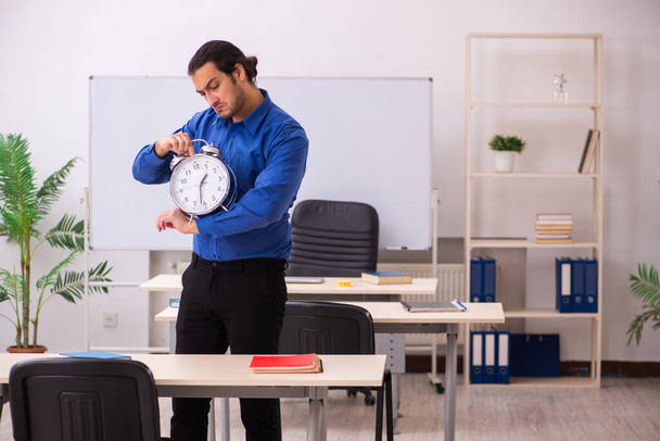 Fiatal férfi tanár az időgazdálkodás koncepciójában - Fotó, kép