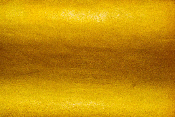 Fondo de textura dorada con lujosa lámina amarilla brillo brillante brillo de reflejo de luz brillante en la superficie dorada - Foto, Imagen