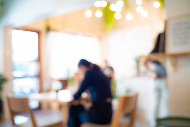 Abstrakte verschwommene Menschen sitzen im Café-Restaurant mit leichtem, gemütlichem geschäftlichen Hintergrund - Foto, Bild