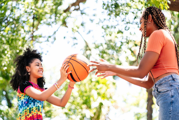 Mother and daughter playing basketball at park. - Foto, Imagem