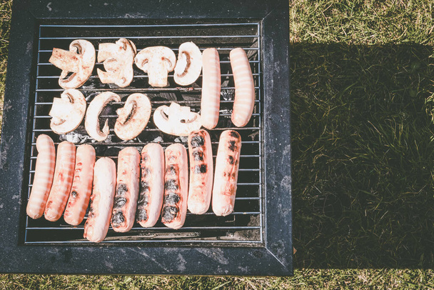 Sausages grilled, outdoor recreation. Portable barbecue - Photo, Image