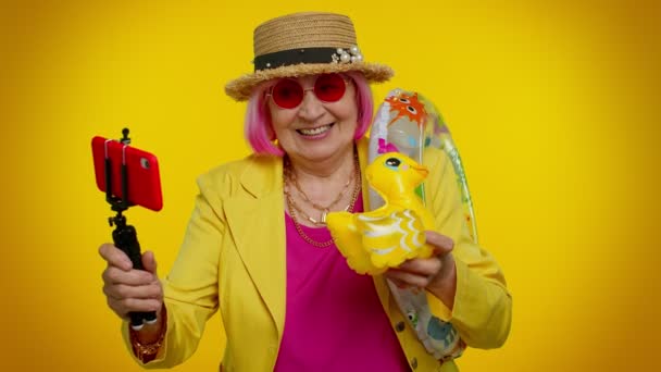 Mature grand-mère voyageur blogueur dans les lunettes de soleil, prendre selfie sur téléphone mobile, appel vidéo en ligne - Séquence, vidéo