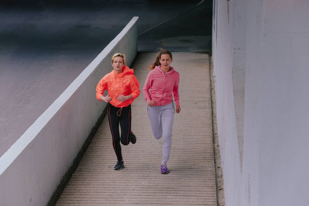 Young healthy female runners during an urban workout routine - Zdjęcie, obraz
