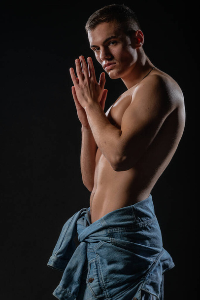 Seksikäs mies, jolla on alaston vartalo poseeraa sinisissä farkuissa farkkutakki vyötäröllään - Valokuva, kuva