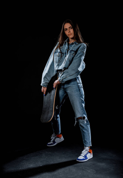Stilvolle junge Frau in blauer Jeanshose und abgeschnittener Jeansjacke - Foto, Bild