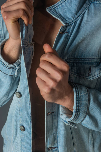 Imagem de um jovem macho bonito com abdominais e jaqueta de ganga aberta e jeans. - Foto, Imagem