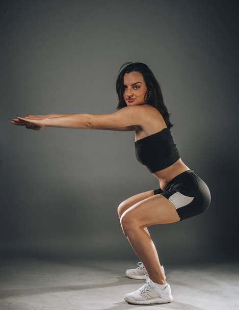 Schöne junge und fitte Fitness-Sport-Model macht Yoga im dunklen Studio - Foto, Bild