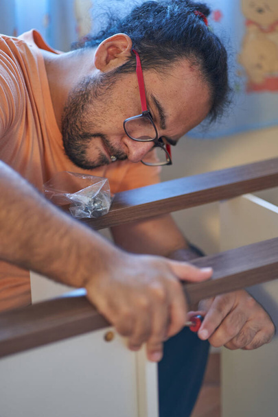 Man detail when assembling wooden furniture at home. Carpentry session - Фото, зображення