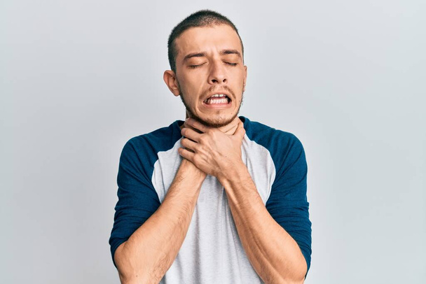 Іспанський молодий чоловік у повсякденному одязі кричить і душить, тому що болючий задух. проблеми зі здоров'ям. задум і самогубство..  - Фото, зображення