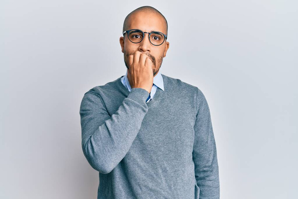 Hispanic adult man wearing glasses and business style looking stressed and nervous with hands on mouth biting nails. anxiety problem.  - Photo, Image